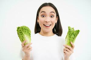 contento coreano mujer vegetariano, sonriente y demostración repollo, comiendo lechuga en dieta, Guías activo estilo de vida, blanco antecedentes foto
