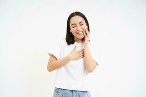 despreocupado asiático mujer, riendo y sonriente, muestra sincero emociones, posando contento en contra blanco antecedentes foto
