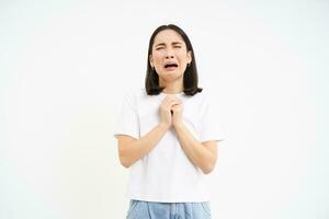 Desperate young woman, girl crying and pleading, asking for help, begging for something, white background photo