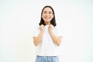 Excited, super happy asian woman jumping from joy, standing over white background photo