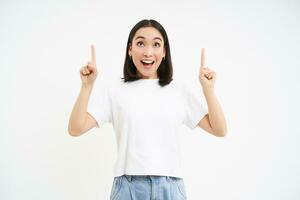 Portrait of beautiful happy woman, student smiling and pointing fingers up, showing banner, recommends promotion, isolated on white background photo