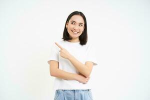 retrato de hermosa sonriente asiático mujer, señalando dedo izquierda, demostración anuncio publicitario, recomendando sitio web, aislado en blanco antecedentes foto