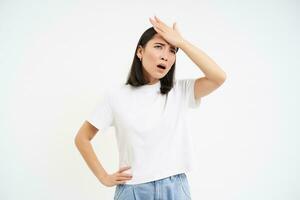 Troubled young woman, slaps her forehead, look bothered, forgot remember smth, isolated on white background photo