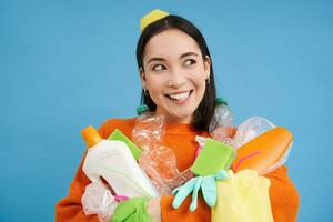 retrato de sonriente asiático mujer con el plastico basura, participación residuos y mira feliz, recoge camada para reciclaje centro, sostenible estilo de vida concepto foto