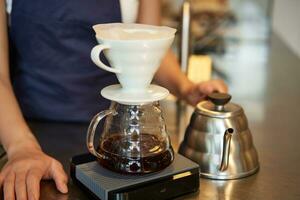 Close up of filter coffee brewing kit and kettle, cafe barista preparing filter at the counter photo