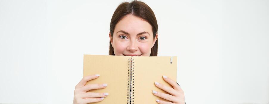 imagen de joven mujer con computadora portátil, participación su personal diario, trabajo planificador, sonriente, leyendo algo, en pie terminado blanco antecedentes foto