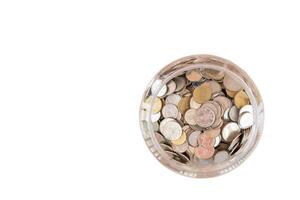 top view of Thai coins in transparent plastic jar isolated on white background. Concept of saving money for the future or money growth photo