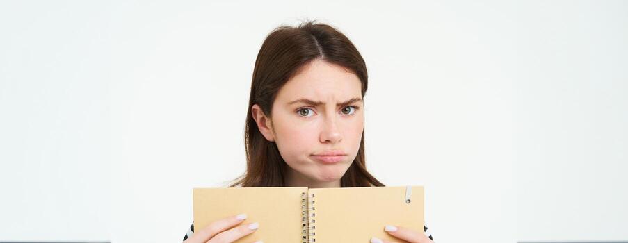 retrato de niña mirando desconcertado, perplejo cara de mujer, participación computadora portátil, confuso por algo, en pie terminado blanco antecedentes foto