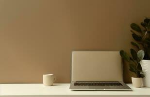 AI generated a picture of laptop, notebook, notepad, and plant on a table. photo