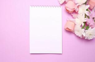 AI generated pink flowers with white blank notepad standing on a pink counter. photo