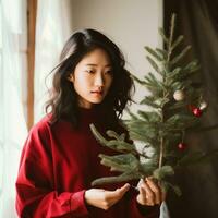 ai generado mujer con rojo suéter participación Navidad árbol, foto