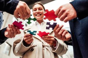 Businessmen working together to build a puzzle as teamwork, partnership and integration concept photo