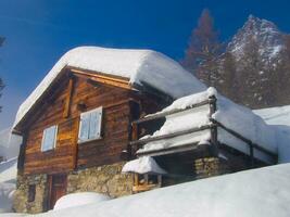 a wooden house covered in snow photo