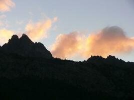 a plane flying over a mountain with clouds photo