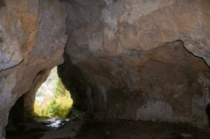 a cave with a man standing inside photo