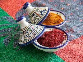 two bowls with spices and spices on a colorful tablecloth photo