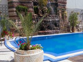 a blue pool with a fountain photo