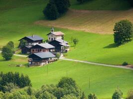 un pequeño granja casa en el medio de un lozano verde campo foto