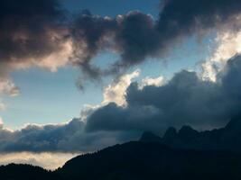 a beautiful sunset over the mountains with clouds photo