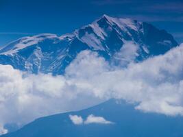 a plane flying over a mountain photo