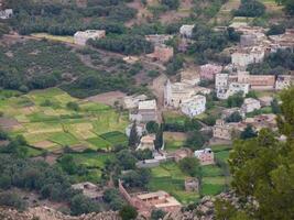 un pueblo en el montañas con verde campos y arboles foto