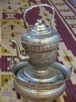 a silver tea pot on a table photo