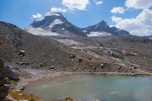 a small lake in the middle of a mountain photo