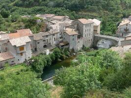 a small village with a river running through it photo