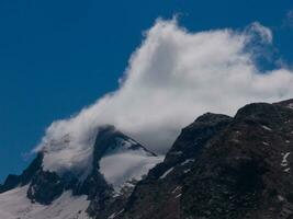 a mountain with a cloud in the sky photo