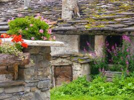 stone house with a wooden bench photo