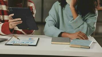 negocio equipo reunión trabajando con nuevo puesta en marcha proyecto, discusión y análisis datos el cartas y gráficos digital tableta, calculadora, ordenador portátil computadora usando, negocio Finanzas y contabilidad concepto. video