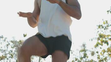 Athletic runner doing stretching exercise, preparing for running in the nature with the city in background. Healthy lifestyle video