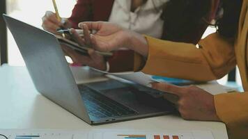 negocio equipo reunión trabajando con nuevo puesta en marcha proyecto, discusión y análisis datos el cartas y gráficos digital tableta, calculadora, ordenador portátil computadora usando, negocio Finanzas y contabilidad concepto. video