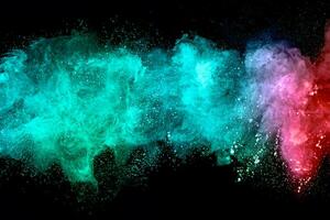 Abstract multicolored powder explosion on black background. Red and blue dust particles splattered on background. photo