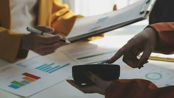 negocio equipo reunión trabajando con nuevo puesta en marcha proyecto, discusión y análisis datos el cartas y gráficos digital tableta, calculadora, ordenador portátil computadora usando, negocio Finanzas y contabilidad concepto. video