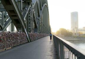 People walk across the Hohenzollern Bridge, Cologne photo