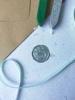 un vertical Disparo de cera moneda con cinta, cera talón en gris superficie foto