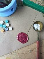 a vertical shot of wax coin with ribbon, wax bead on grey surface photo