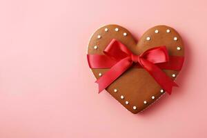 AI generated Gingerbread heart with a pink ribbon on a pink background. photo