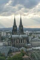 dramático tormenta nubes terminado Colonia catedral y hohenzollern puente en el puesta de sol foto