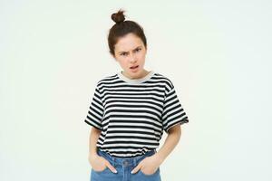 Image of woman looking with arrogant, frustrated face, frowning and staring at you with bothered threatening expression, standing over white background photo