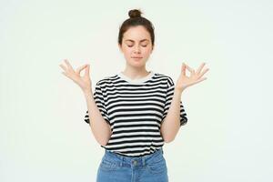 mantener calma y meditar. joven mujer relajante, en pie en asanas, zen pose, participación manos oblicuo y meditando, en pie terminado blanco antecedentes foto