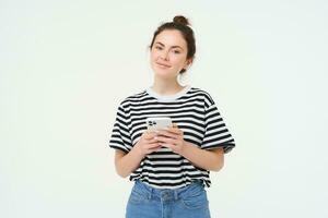 Image of young smiling woman, holding mobile phone, using smartphone application, isolated over white background photo