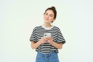 Image of young smiling woman, holding mobile phone, using smartphone application, isolated over white background photo