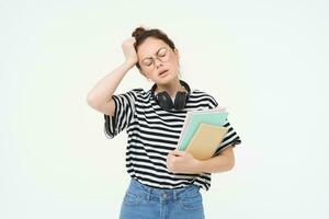 Portrait of young tired student, girl has headache, touching head with troubled face expression, sighing from complicated situation, standing over white background photo