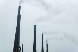 smoking chimneys of a diesel power plant against a cloudy sky photo
