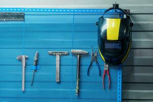 welding mask hanging on a stand with tools photo