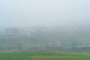 rural paisaje con casas y graneros en grueso niebla foto