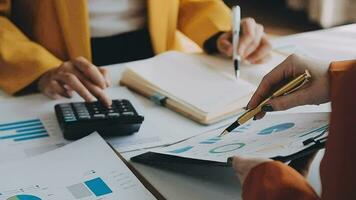 negocio equipo reunión trabajando con nuevo puesta en marcha proyecto, discusión y análisis datos el cartas y gráficos digital tableta, calculadora, ordenador portátil computadora usando, negocio Finanzas y contabilidad concepto. video