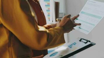 negocio equipo reunión trabajando con nuevo puesta en marcha proyecto, discusión y análisis datos el cartas y gráficos digital tableta, calculadora, ordenador portátil computadora usando, negocio Finanzas y contabilidad concepto. video